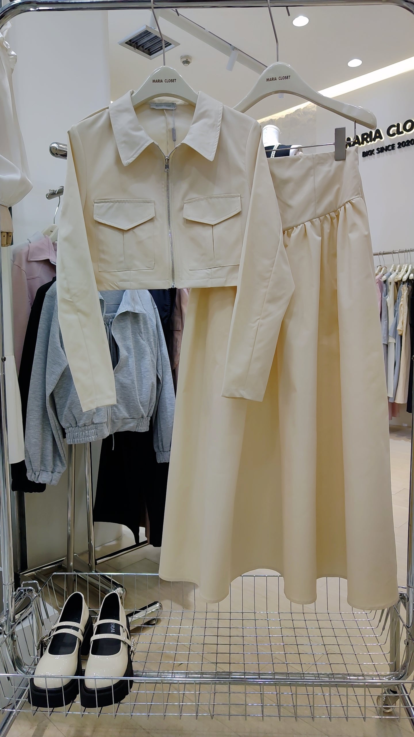 The "Classic Vest" Co-ord Set in cream with zip-front vest and matching long skirt on hanger.