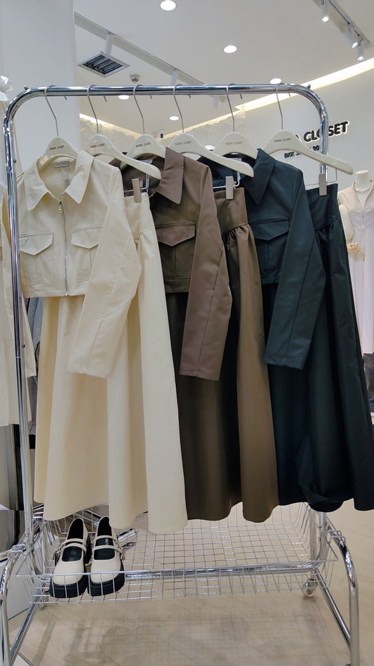 The "Classic Vest" Co-ord Set in cream, brown, and black hanging on a rack in a retail store.