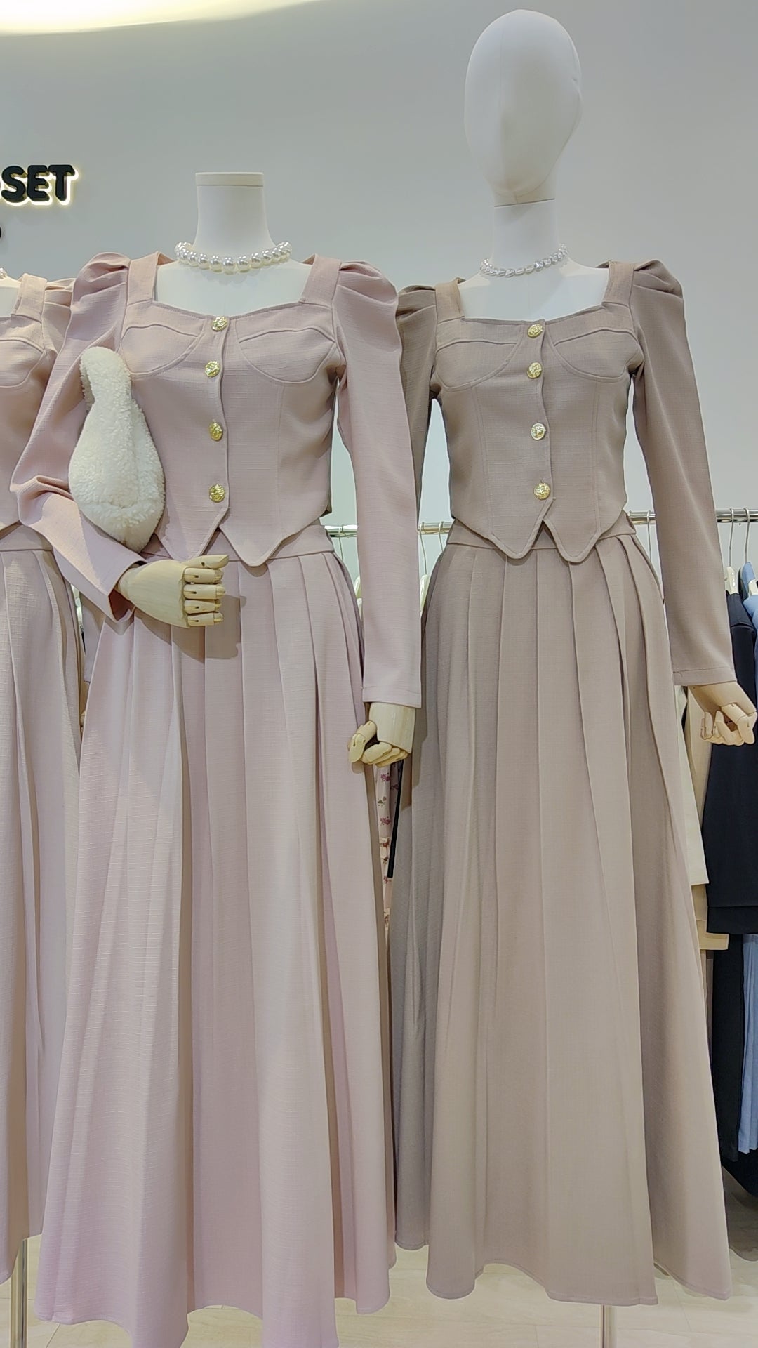 The "Flowy Tweed" Co-ord Set in soft neutral tones with pleated long skirts and buttoned tops on mannequins.