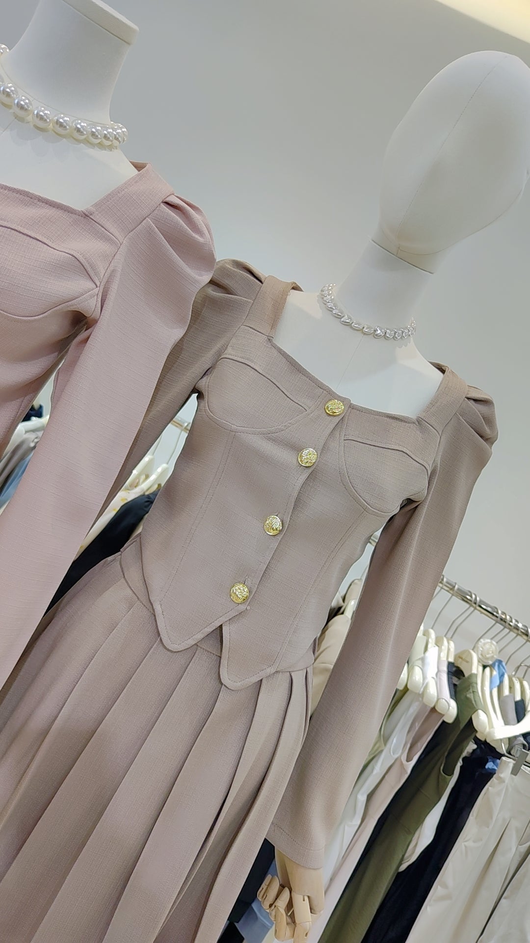 The "Flowy Tweed" Co-ord Set features a long pleated skirt and fitted top with gold buttons in soft beige tones.