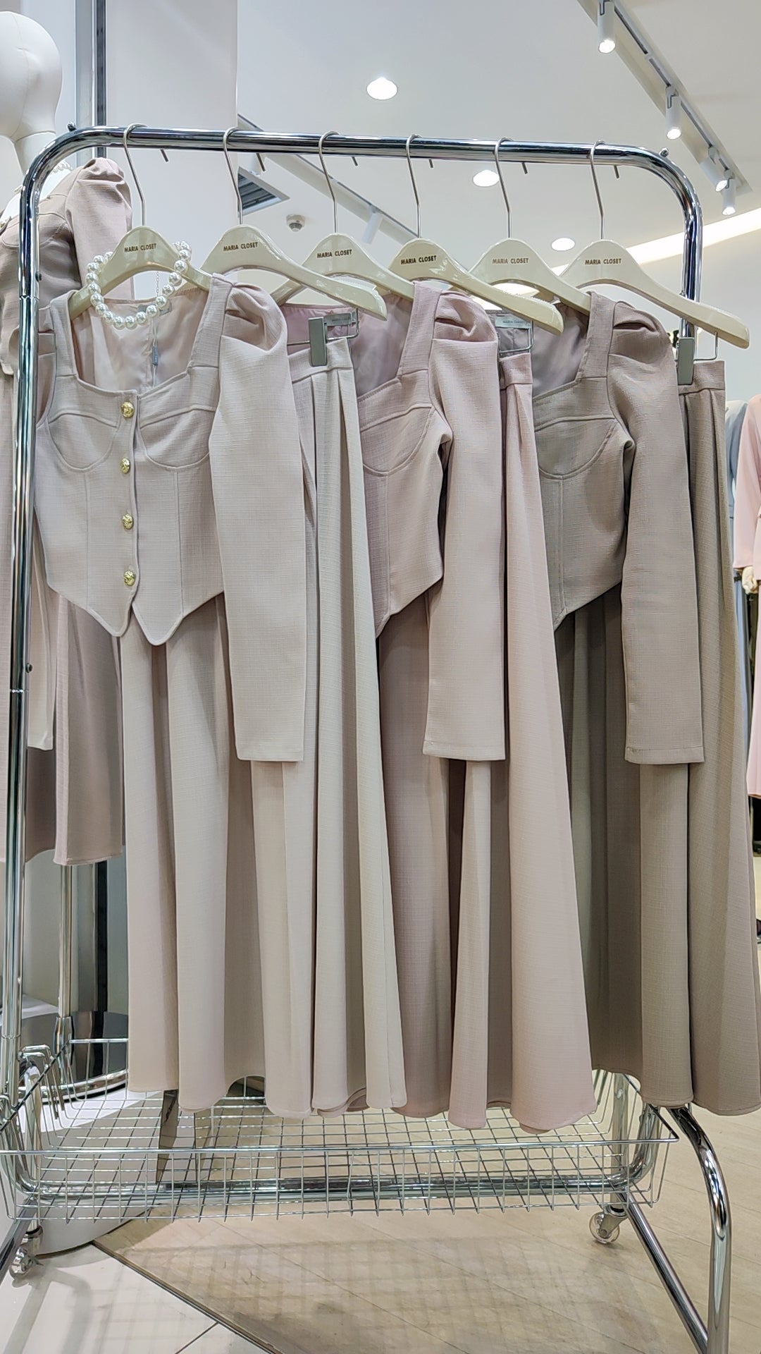 The "Flowy Tweed" Co-ord Set displayed on hangers, featuring a fitted top and long flowing skirt in soft neutral tones.