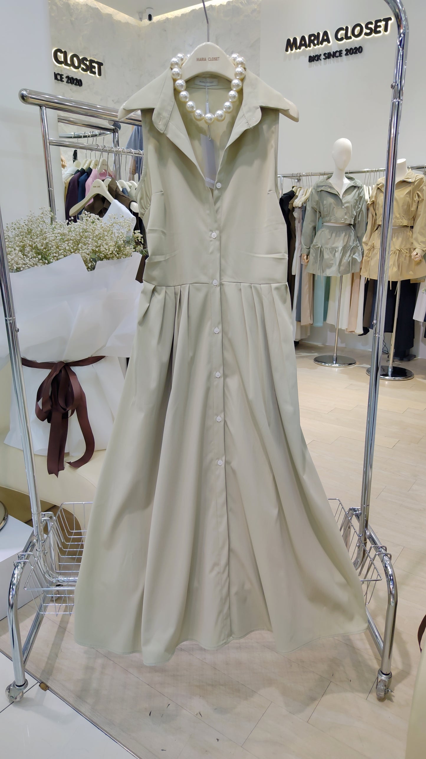 The "Everyday" Sleeveless Shirt Dress in beige cotton with button front and classic collar displayed on hanger.