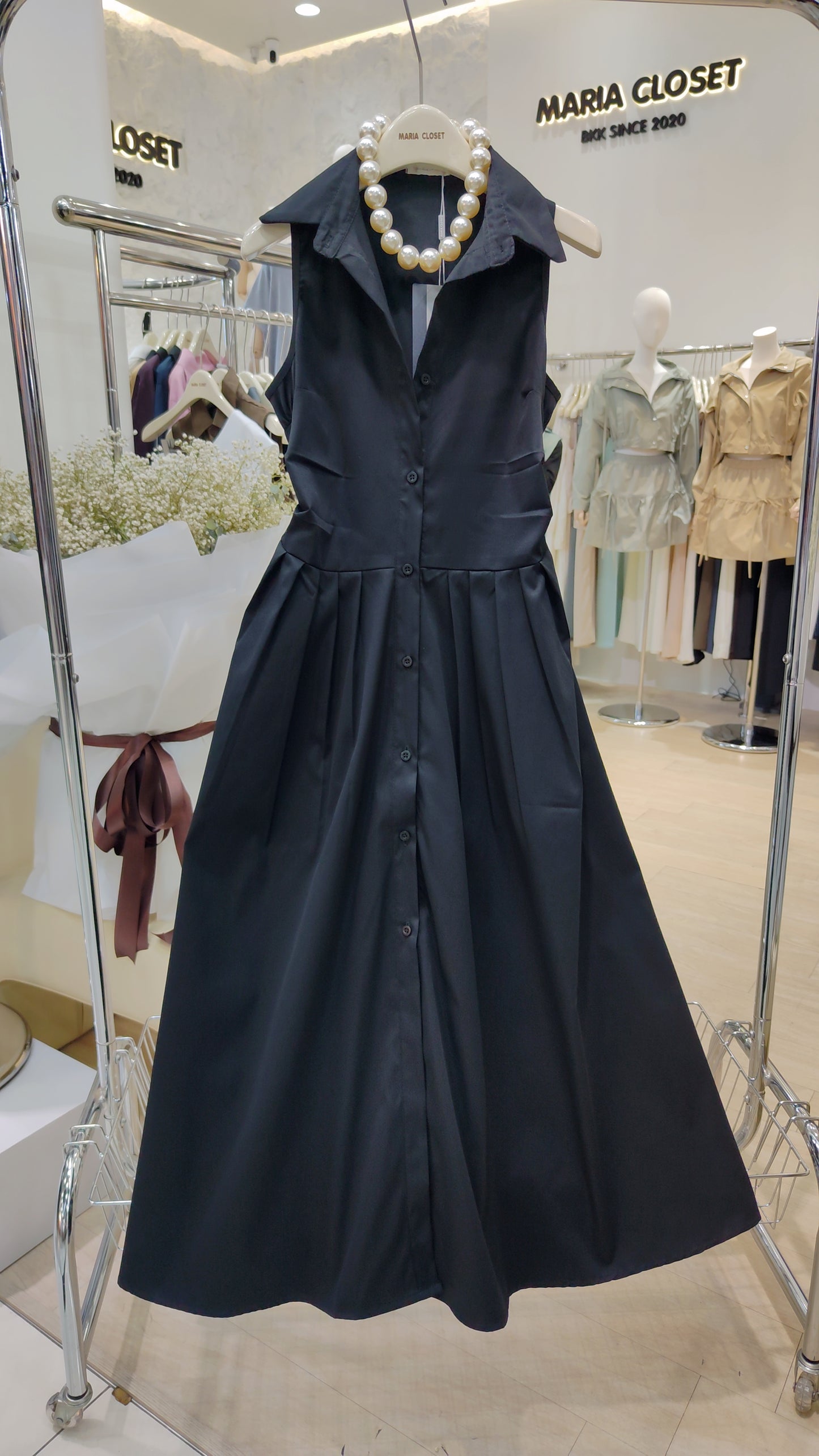 The "Everyday" Sleeveless Shirt Dress in black cotton with collar and full button front displayed on a hanger.