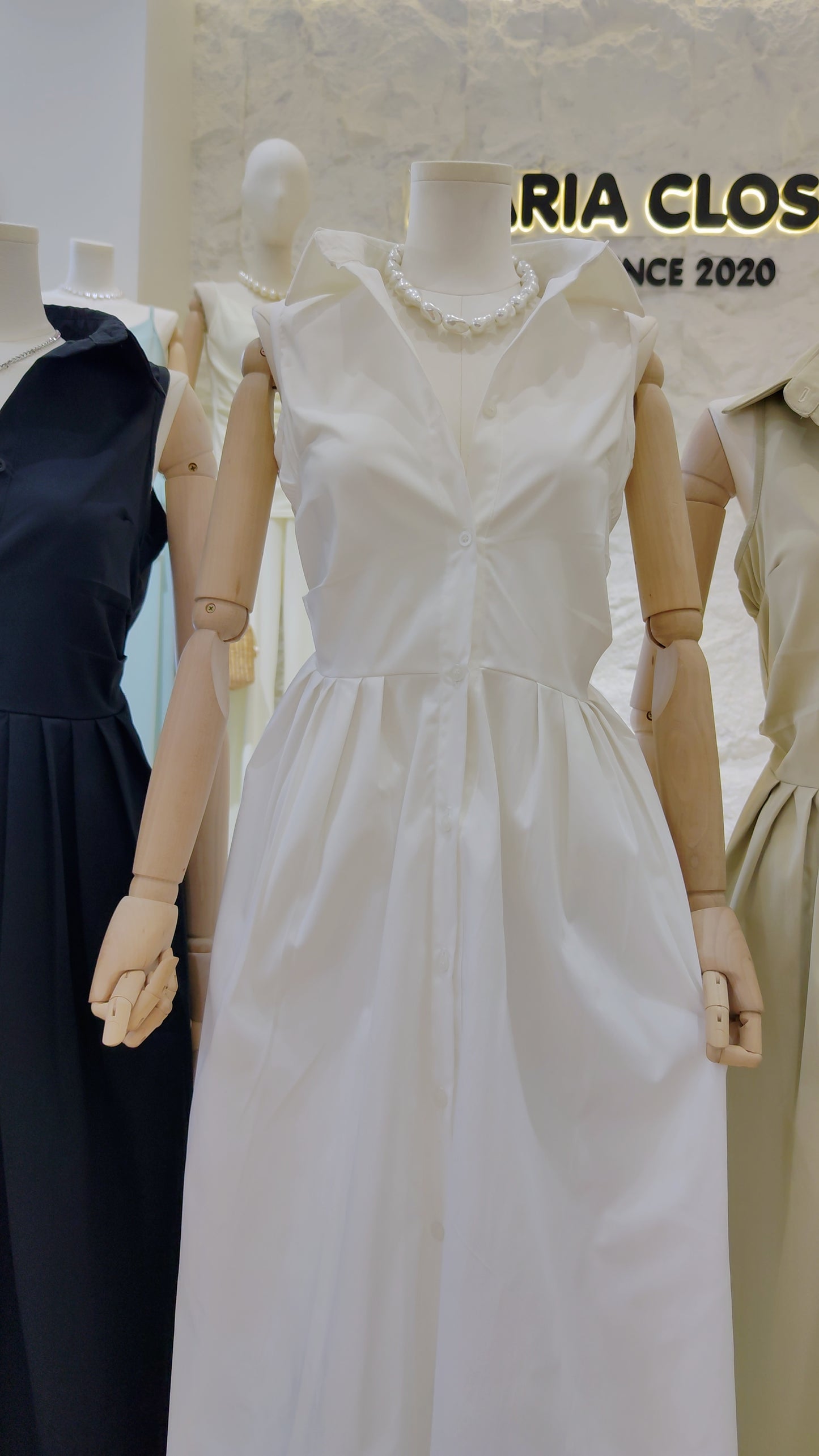 Mannequin dressed in the white "Everyday" Sleeveless Shirt Dress with classic collar and button-front design.
