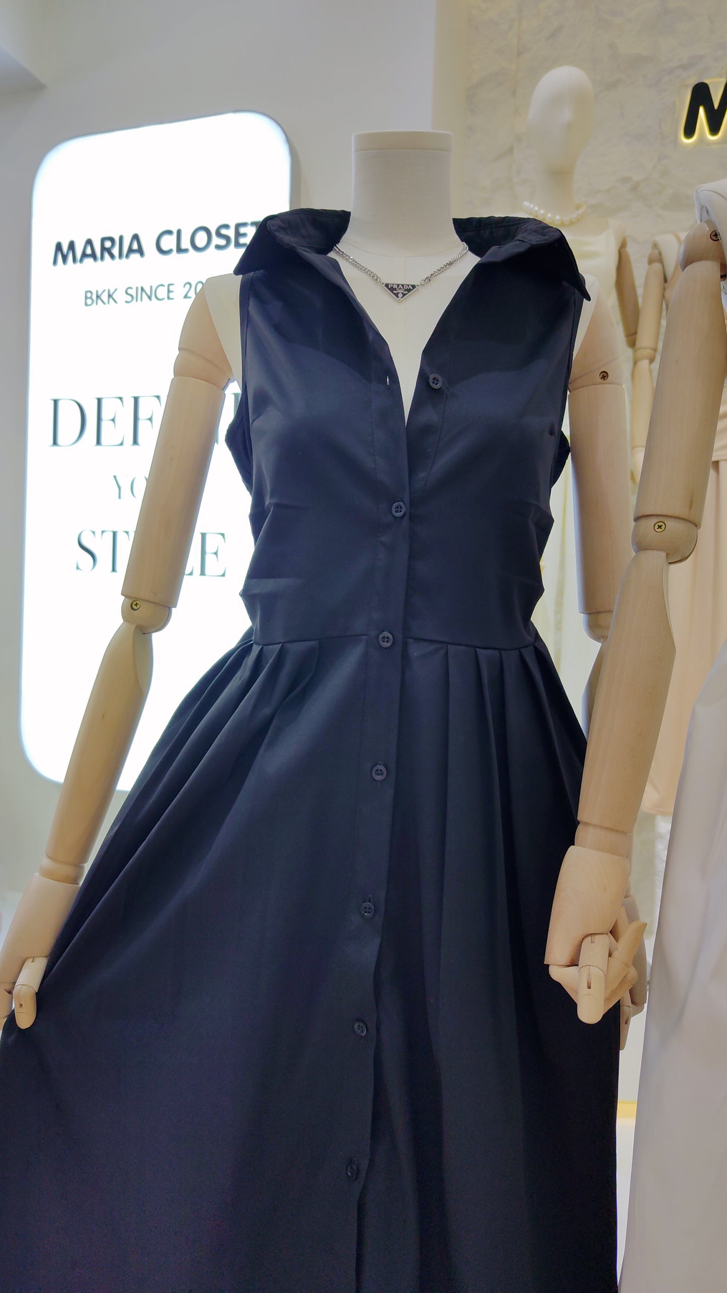 The "Everyday" Sleeveless Shirt Dress in navy with collar and full button front on a mannequin.