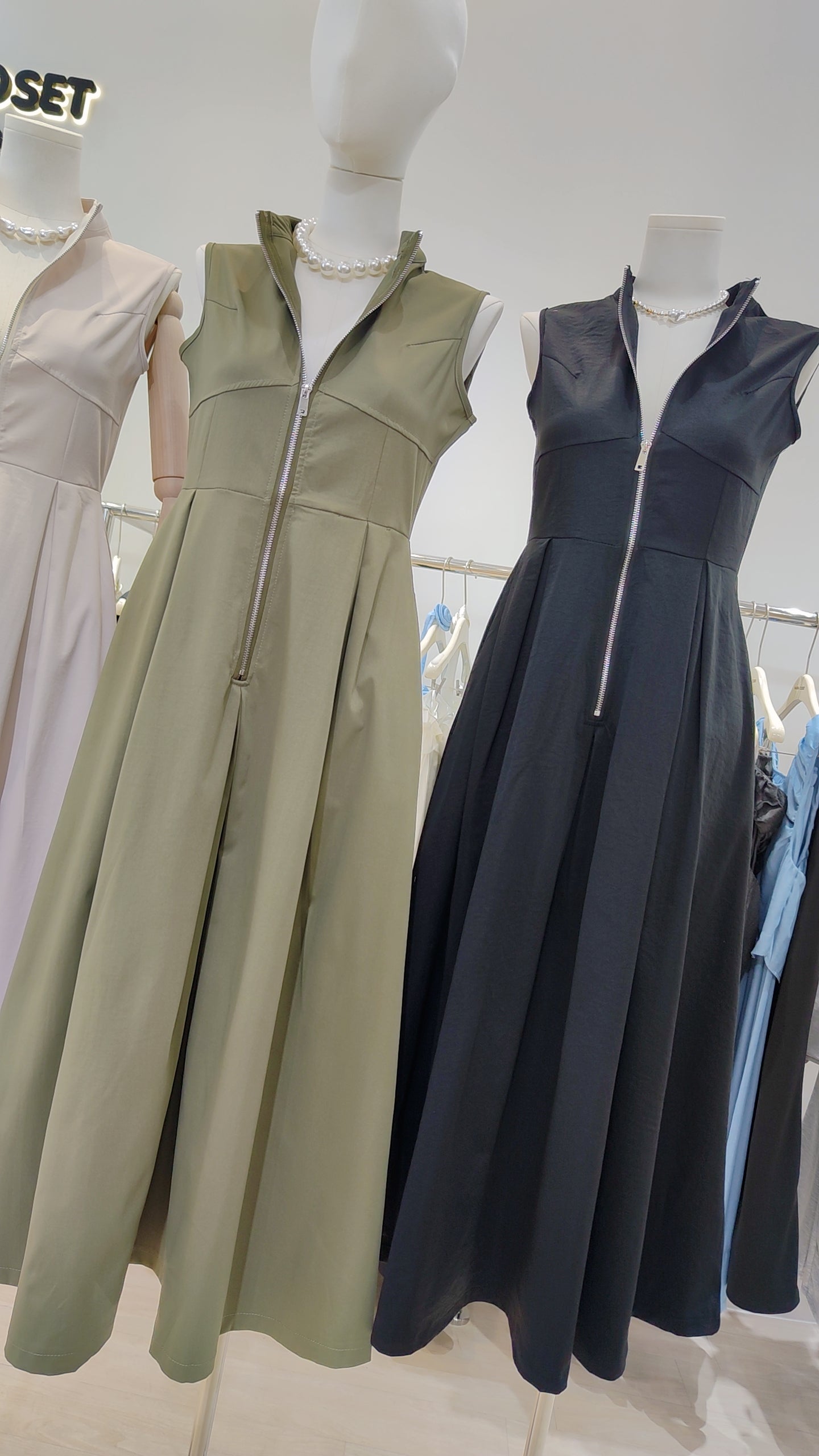 The "Urban Zip-Front" Maxi Dress in olive green and black with sleeveless design and front zipper closure.