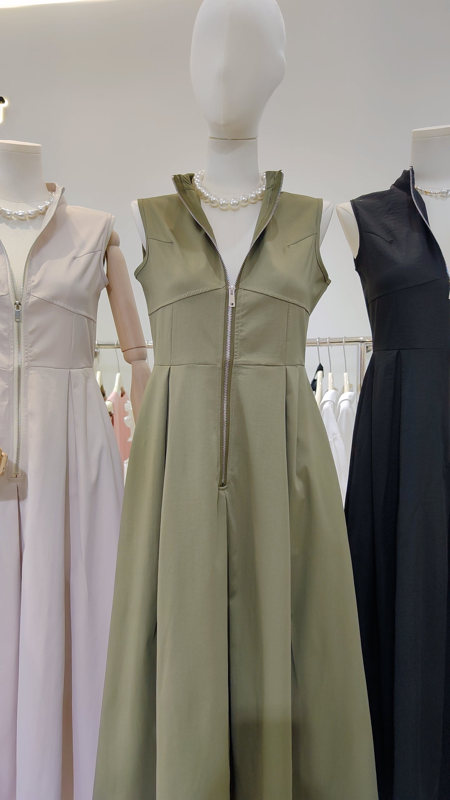 The Urban Zip-Front Maxi Dress in olive green with sleeveless design and full-length front zipper on a mannequin.