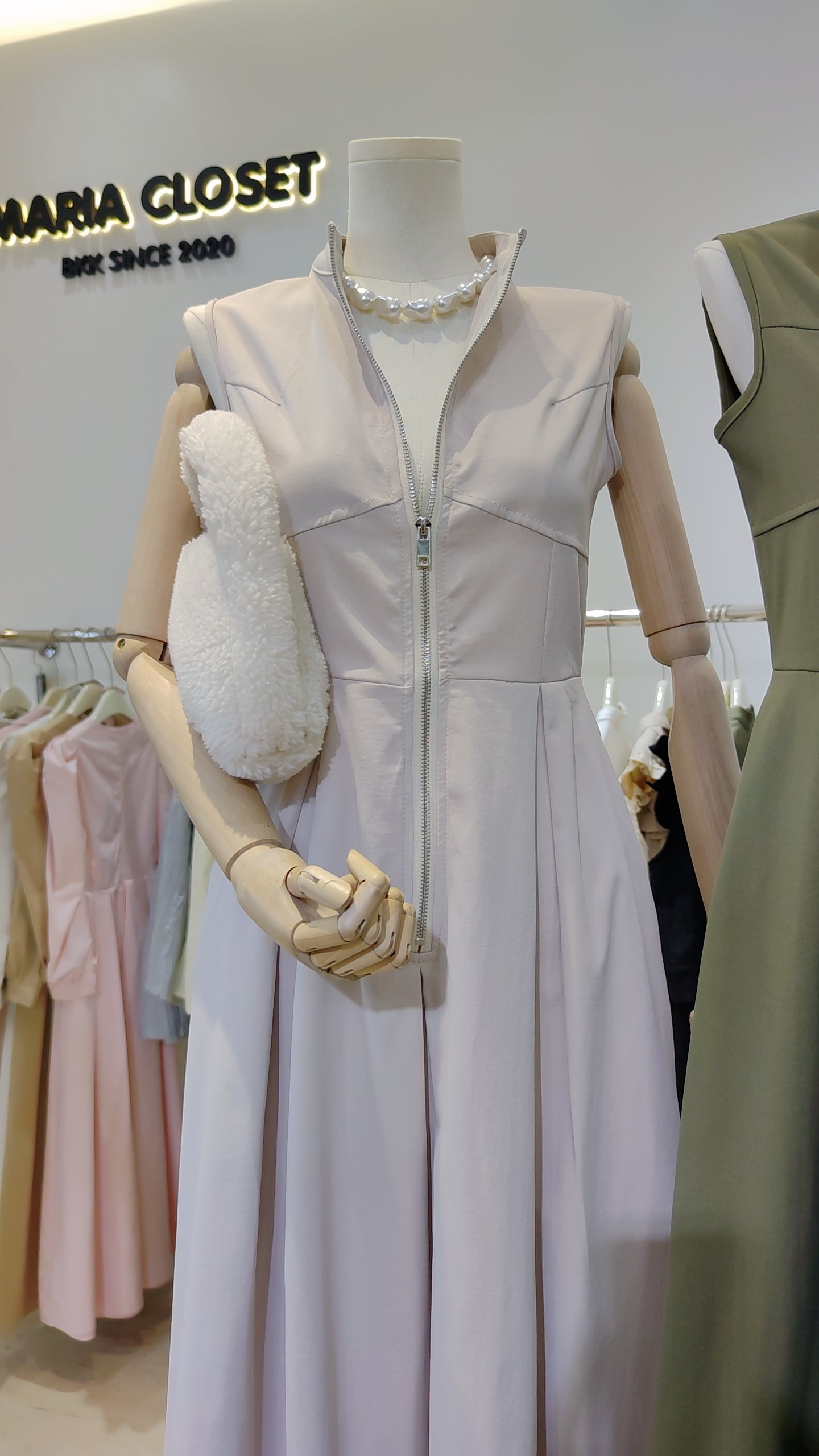 Mannequin wearing The Urban Zip-Front Maxi Dress in light color with front zipper and sleeveless design.