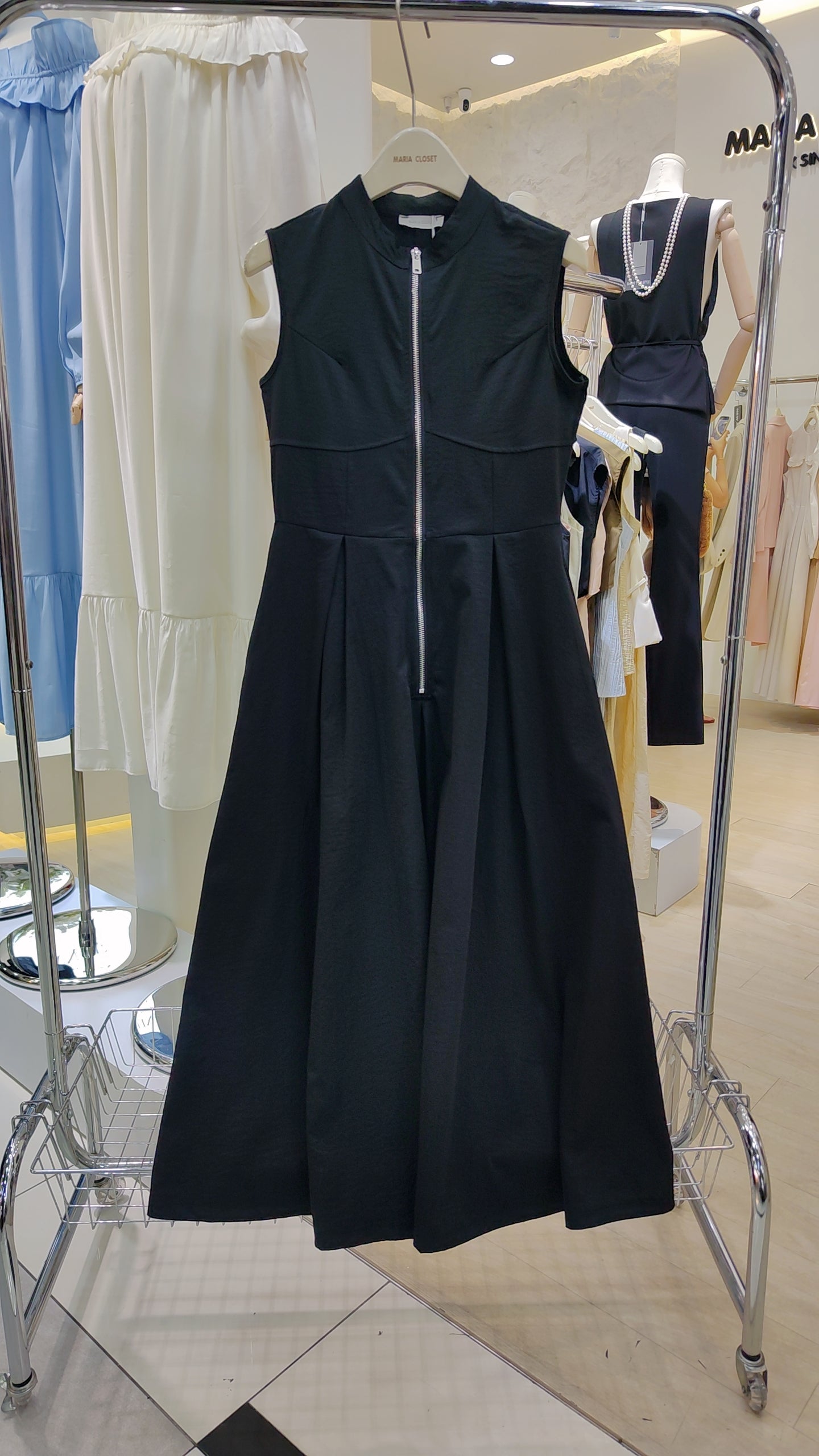 The "Urban Zip-Front" Maxi Dress in black with sleeveless design and full-length front zipper on display.
