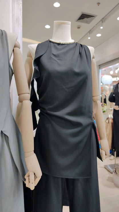 The "Flowy Tunic" Two-Piece Set in black with sleeveless ruffle hem tunic and wide-leg pants on mannequin.
